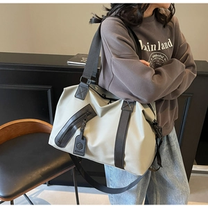 Detail of light grey travel duffel bag with water-resistant fabric and front zipper pocket