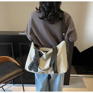 Detail of off-white large capacity travel bag with leather handles and detachable strap