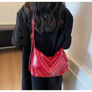 Detail of red glossy leather hobo bag with large capacity and minimalist shoulder strap