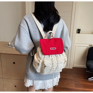 Rear view of casual large capacity backpack with red flap and beige body on a model