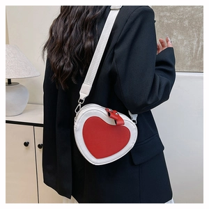 Detail of red and white heart-shaped leather crossbody bag with woven shoulder strap