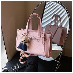Pink lychee texture handbag featuring a plush bear charm and mirror reflection detail