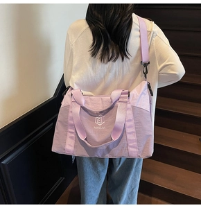 Detailed back view of a large purple lavender travel bag on a model on stairs