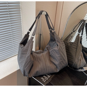 Detail of grey quilted tote bag featuring vertical pleated texture and large capacity