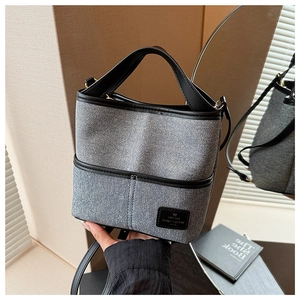 Détail du sac seau en jean et cuir avec poignée noire et bandoulière réglable