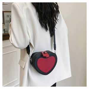 Detail of heart-shaped crossbody bag with black and red PU leather and dual zippers
