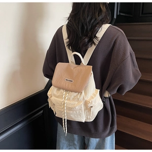 Detailed back view of a minimalist cream and khaki nylon backpack with multiple pockets