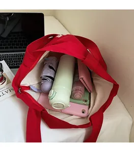 Interior view of red canvas tote bag showing large capacity with daily essentials