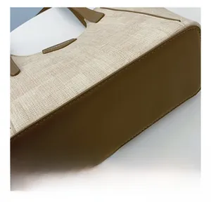 Close-up of double stitching on the canvas tote bag with brown leather base detail