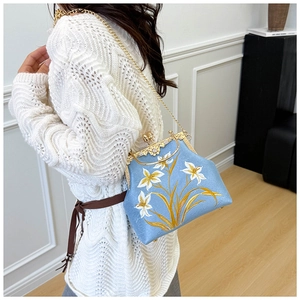 Light blue embroidered canvas bag with gold chain strap and lily flower pattern detail