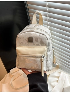 Mini champagne silver backpack with leaf texture and stud details shown by model