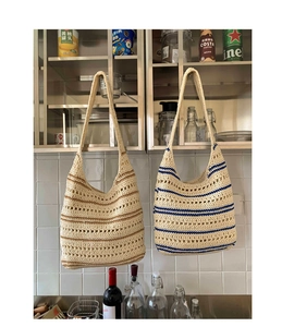 Detailed knit of two color-blocked woven tote bags in brown and blue stripes