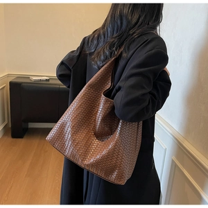 Close-up of brown leather woven hobo bag showing intricate handmade mesh texture