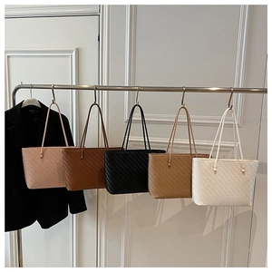 Detailed row of woven tote bags in pink, brown, black, tan, and white colors