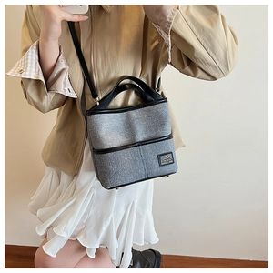 Gros plan détaillé du sac seau à paillettes grises avec sangles noires et pieds de protection