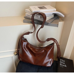 Detail showing the vintage oily leather texture and soft finish of the large hobo tote bag