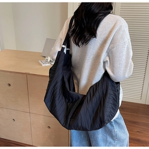 Detail of black pleated hobo bag with vertical textures and large capacity capacity design