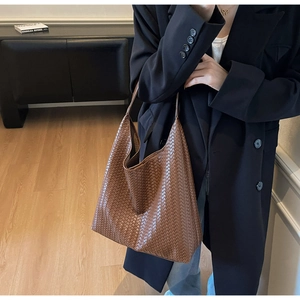 Close-up of brown woven leather tote bag texture and Intrecciato craftsmanship