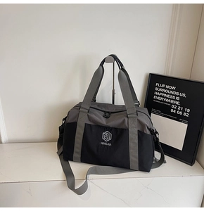 Close-up of durable grey and black travel bag with embroidered logo and adjustable strap