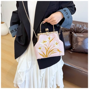 Detailed embroidery on vintage pink canvas bag with golden chain and lily flower pattern