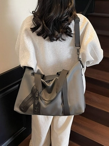 Large capacity dark grey travel tote bag with shoulder strap shown on a staircase
