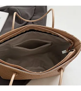 Spacious interior of beige woven tote bag featuring gray herringbone lining and zipper pocket