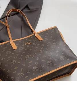 Dettaglio della borsa tote marrone scuro con trama in pelle e motivo monogramma vintage