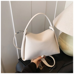 Detail of off-white lychee grain leather handbag with silver hardware and curved base