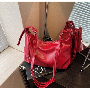Detailed shot of a red leather tote bag with silver buckles and pleated texture