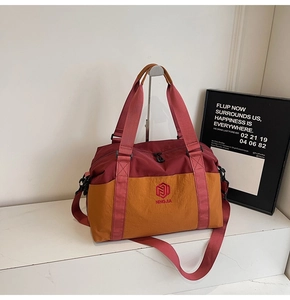Detail of red and yellow duffel bag with NINGJIA embroidery on waterproof nylon