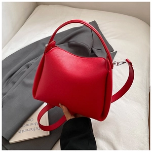 Detail of red lychee pattern leather handbag with silver hardware and sturdy handle