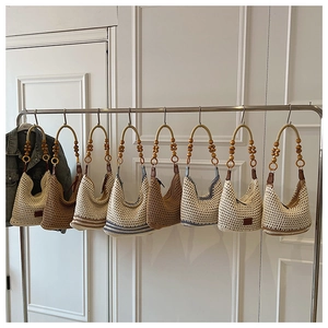 Detail of bohemian knit tote bags featuring wooden bead handles and leather branding