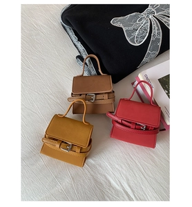 Micro mini leather handbags in red, yellow, and brown shown with decorative silver buckle detail