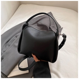 Detail of black lychee grain leather texture on elegant top handle handbag