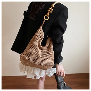 Détail du sac à bandoulière tissé bohème avec perles en bois et texture tricotée