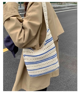 Detail of hand-woven striped tote bag with hollow knit pattern on model shoulder