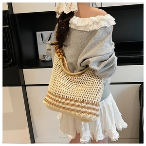 Detail of hollow knit shoulder bag with decorative wooden beads and striped pattern
