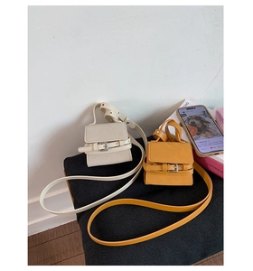 Detailed shot of mini square crossbody bags in beige and yellow faux leather texture