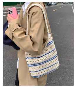 Detail of handwoven tote bag featuring blue stripes and hollow knit texture on a model