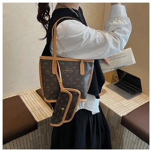 Detail view of large brown tote bag set with vintage pattern and cream-colored piping