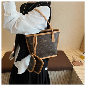 Detail view of brown tote bag with Lazy Breeze logo and matching small charm pouch