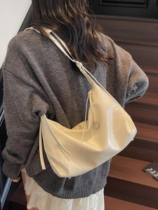 Large cream leather tote bag with glossy finish and minimalist shoulder strap design