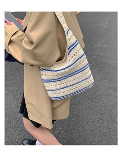 Detail of hand-woven cotton rope tote bag with blue stripes and hollow texture design