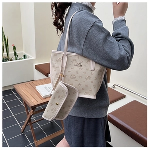 Detail view of the beige Lazy Breeze tote bag with cartoon bear patterns and metal logo