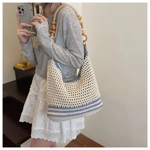 Détail du sac à bandoulière tissé avec design en tricot ajouré et anse en perles de bois