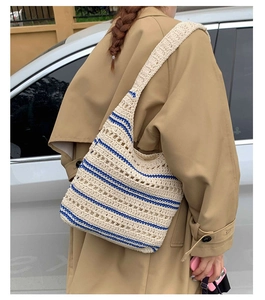Detailed texture of hand-woven shoulder bag with ivory base and deep blue stripes