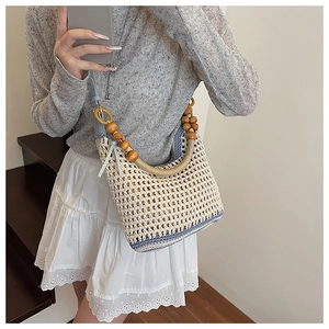 Détail du sac de plage bohème en tricot avec poignée en perles et sangle bleue