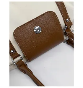 Close-up of durable cream fabric with brown leather trim and silver metal hardware
