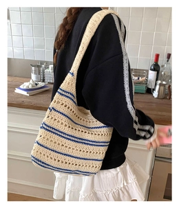 Detail of hollow crochet woven shoulder bag with blue stripes and bohemian texture