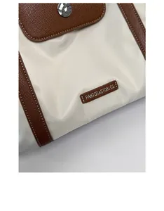 Close-up of white nylon and brown lychee leather texture with magnetic metal buckle
